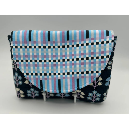 Fabric pouch with checkered pattern and floral accents on a gray background