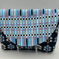 Fabric pouch with checkered pattern and floral accents on a gray background